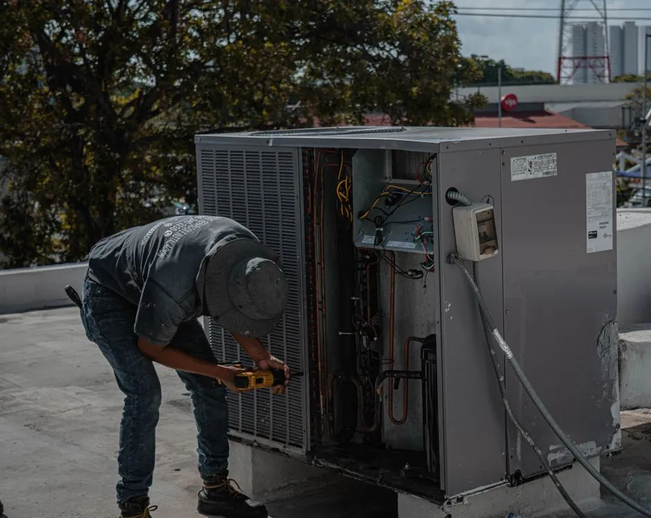 A technician repairing a home appliance unit outdoors